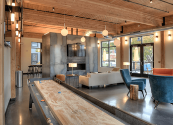 Cozy resident lounge with remote workspaces, large flat screen tv's and tabletop shuffleboard